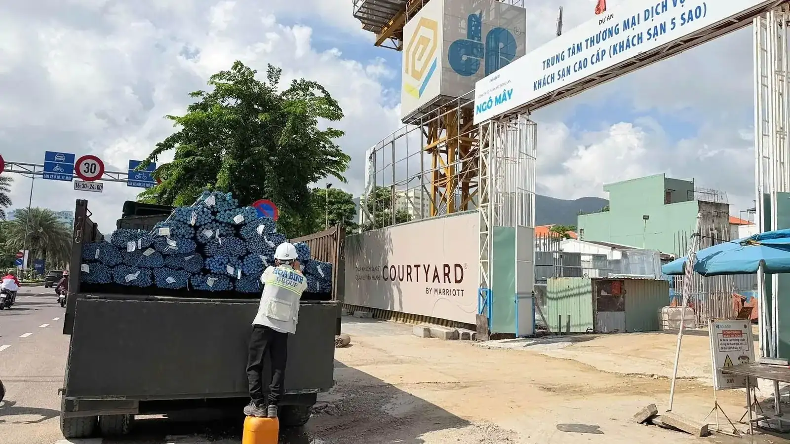 Cổng dự án Q'Terra trên đường Ngô Mây, tháp khách sạn Courtyard by Marriott đang thi công